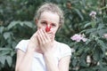 Allergy. Woman squeezed her nose with hand, so as not to sneeze from the pollen of flowers. Woman protecting her nose from Royalty Free Stock Photo