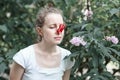 Allergy. Woman squeezed her nose with hand, so as not to sneeze from the pollen of flowers. Woman protecting her nose from Royalty Free Stock Photo