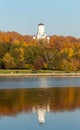 Alley along the riverbank on the background of the autumn park. Ancient tower the Orthodox Church of Beheading of John the Baptist