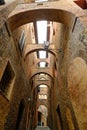 Alley with arches in the Tuscan city of Siena. Terracotta brick walls of the ancient houses