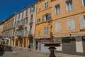 Alley with buildings, woman and fountain in Aix-en-Provence. Royalty Free Stock Photo