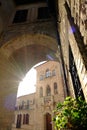 Alley of the city of Assisi with arch and vault. The walls of the houses are built with light colored stone