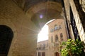 Alley of the city of Assisi with arch and vault. The walls of the houses are built with light colored stone