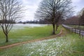 Alley in Cranford Park on an overcast day. Snowfall in March Royalty Free Stock Photo