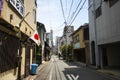 Alley in downtown Kyoto with small houses and electrical network cable. The national flag of Japan or hinomaru on one of the house