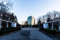 Alley of Greek statues in the Herastrau park and the high rise business building in Aviatorilor Square Royalty Free Stock Photo