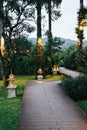 The alley in the hotel in the garden, lanterns glow at dusk around the lawns and palm trees. Evening cozy atmosphere Royalty Free Stock Photo