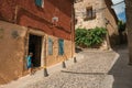 Alley with old building and boy next to open door at Caceres
