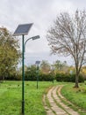 Alley in the park with lighting poles and photovoltaic panel LED lamp lights Royalty Free Stock Photo