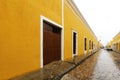 Alley surrounded by yellow buildings during the rain in Izamal, Mexico Royalty Free Stock Photo