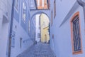 Alley between two lavender buildings with windows in Cesky Krumlov, Czech Republic. Royalty Free Stock Photo