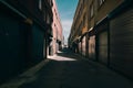 Alleyway stands desolate under building shadows, evoking solitude