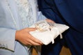 Alliances wedding rings on white pillow in groom hands for the marriage couple