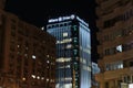 Allianz-Tiriac Tower illuminated office building between regular buildings at Victory Square at night Royalty Free Stock Photo