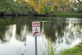 Alligator warning sign in Florida park about caution and safety during walking near water