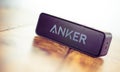 Alloa, Scotland - July 17: Black wireless bluetooth speaker by ANKER isolated on wooden background