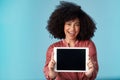 Allow me to introduce a lovely new app. Studio shot of a young woman holding a digital tablet with a blank screen