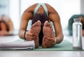 Allowing my body to release. an unrecognisable group of women practising yoga and holding a seated forward fold pose.