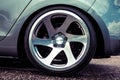 Alloy wheels of a sports car. Polished to shine. On a gray car. Close up
