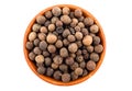 Allspice berries in light brown ceramic bowl