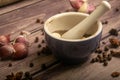 Allspice in a ceramic mortar and scattered garlic cloves, star anise and allspice on a wooden table. Close up Royalty Free Stock Photo