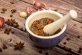 Allspice in a ceramic mortar and scattered garlic cloves, star anise and allspice on a wooden table. Close up Royalty Free Stock Photo