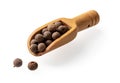 Allspice jamaica pepper in a small wooden scoop cutout. Wooden spice shovel full of dried pimento berries isolated on a white Royalty Free Stock Photo