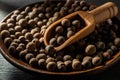 Allspice jamaica pepper in a wooden scoop over allspice grains on a wooden plate. Macro of whole dried pimento berries in the Royalty Free Stock Photo