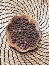 Allspice pepper on an ornamental wood plate