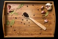 Allspice in a wooden spoon on a wooden tray. Garlic and bay leaf. View from above. Seasoning flavoring for meat and food.