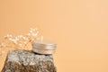 alluminum cream jar on stone with dry flowers on beige background Royalty Free Stock Photo