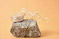 alluminum cream jar on stone with dry flowers on beige background Royalty Free Stock Photo