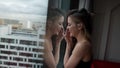 alluring lady is viewing in window in modern apartment in high building, medium portrait Royalty Free Stock Photo