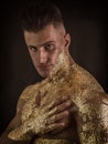 Alluring naked man in gold on black background Royalty Free Stock Photo