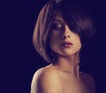 Alluring portrait of short bob hair style woman looking down on black background. Closeup portrait. Toned