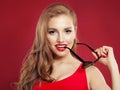 Alluring woman with sunglasses and red lips makeup on colorful red background Royalty Free Stock Photo