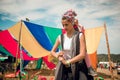 FourE ethnic festival, babywearing mother wrapping her toddler daughter on her back Royalty Free Stock Photo