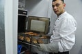 Almaty, Kazakhstan - 11.07.2012 : The chef takes out freshly baked fish for sale in a large hypermarket