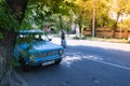 A blue soviet lada car is parked on the road