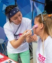 ALMATY, KAZAKHSTAN - JUNE 10, 2018: Unidentified girl makeup artist makes a bright carnival face painting to the