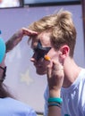 ALMATY, KAZAKHSTAN - JUNE 10, 2018: Unidentified girl makeup artist makes a bright carnival face painting to the