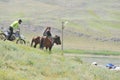 Almaty, Kazakhstan - 04.27.2013 : A man wearing a helmet on a motorcycle rides past riders on horseback. Eco-festival on the banks