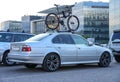 Almaty, Kazakhstan - May 4, 2023: A BMW 5 Series car is parked with a bicycle on the roof Royalty Free Stock Photo