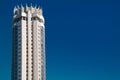 Top of tall building with crown against the vivid blue sky