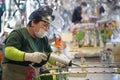 Almaty, Kazakhstan - 02.15.2022 : The worker applies an adhesive agent for soldering car parts. Hyundai Factory