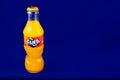 Almeria, Spain; November 25th, 2021: 200ml Orange flavoured Fanta bottle, Classic glass bottle with metal cap isolated on blue.