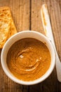 Almond butter in bowl with crackers on wooden table Royalty Free Stock Photo