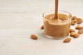 Almond butter, raw food paste made from grinding almonds into nut butter, crunchy and stir, white wooden table, copy space Royalty Free Stock Photo