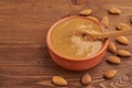 Almond butter, raw food paste made from grinding almonds into a nut butter, crunchy and stir, dark brown wooden table, copy space Royalty Free Stock Photo