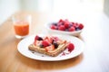almond butter toast with red berry garnish, on a white table